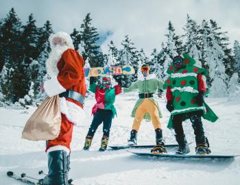 Skiers and snowboarders dressed in holiday attire