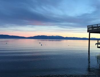 Lake Tahoe at sunset with greens and blues in the sky