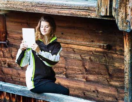 Young woman on her iPad outside of a Lake Tahoe cottage