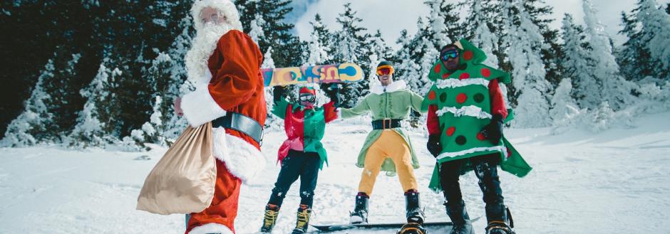 Skiers and snowboarders dressed in holiday attire