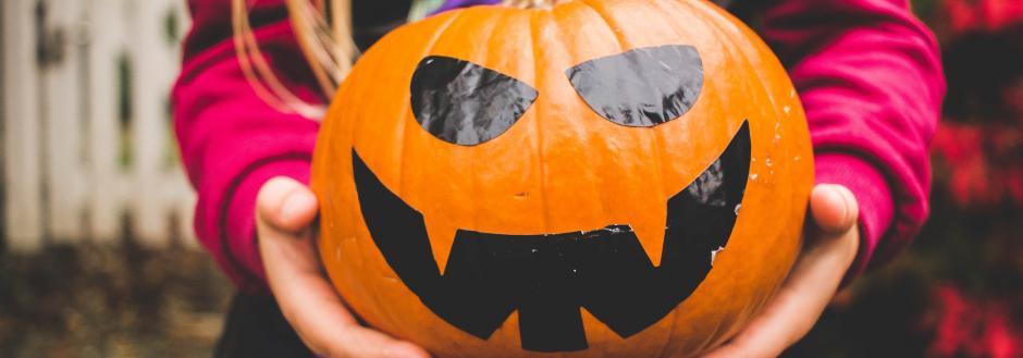 A Jack-O-Lantern design on an orange pumpkin