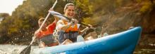 Couple kayaking and smiling 