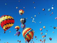 Hot air balloons floating high in the sky at a hot air balloon event